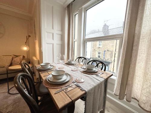 une table à manger avec des chaises et une grande fenêtre dans l'établissement Bank House, Settle, Yorkshire Dales, à Settle