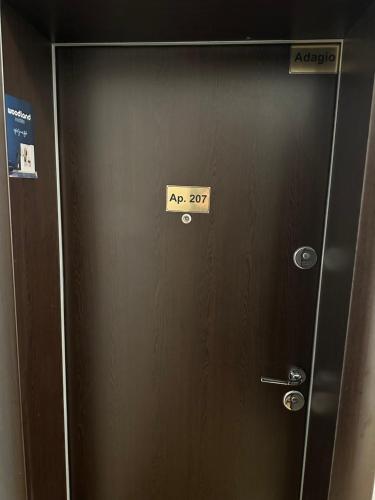 a brown door with a sign on it at Adagio apartment in Creţuleasca