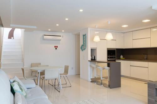 a living room and kitchen with a table and chairs at Mifi Beach Luxury Duplex by MP in Vila Nova de Gaia