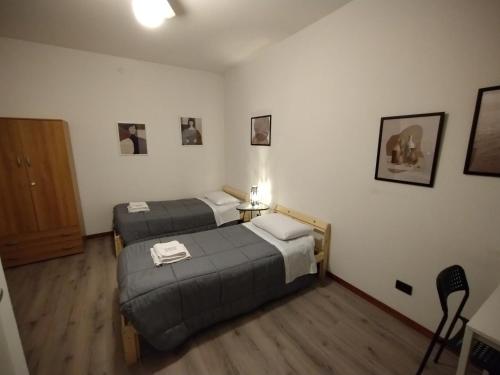 a hotel room with two beds and a door at EasyRoom Schio in Schio