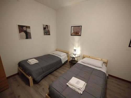 a room with two beds and a table with a lamp at EasyRoom Schio in Schio