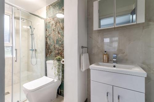 a bathroom with a toilet and a sink and a shower at 12 Elmwood in Harrow