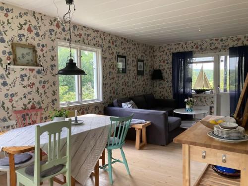 Stuga i Norra Kvarnviken في بينغتسفورس: مطبخ وغرفة معيشة مع طاولة وأريكة