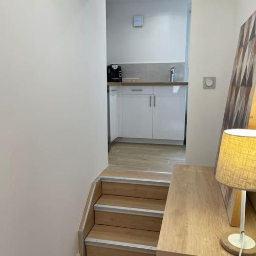 Cette chambre dispose d'une cuisine avec un escalier et une table. dans l'établissement Grand studio 1 avec lave-linge, à Lorient