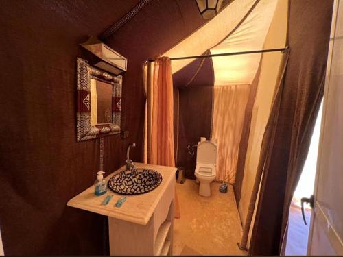 a small bathroom with a sink and a toilet at Sultan Luxury Camp in Merzouga