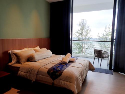 a bedroom with a large bed and a large window at RDHomeStay-RoxyBeachApt in Sematan
