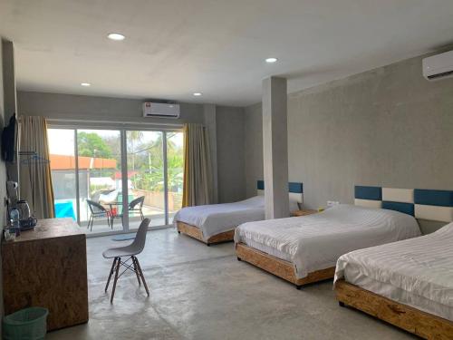 a bedroom with two beds and a table and a chair at 365 View Point Resort in Kaki Bukit