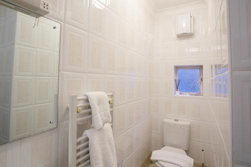 een witte badkamer met een toilet en een raam bij The Buttery in Oxford