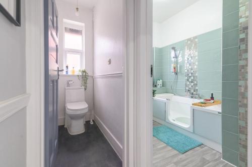 a bathroom with a toilet and a tub and a sink at 12 Elmwood in Harrow