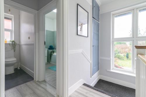 a hallway with a bathroom with a toilet and a window at 12 Elmwood in Harrow