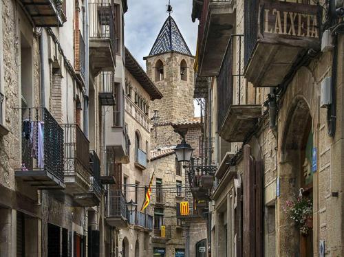 an alley with a building with a tower in the background at Ca la Francisqueta, La Tina i el Deso Apartament Solsona in Solsona