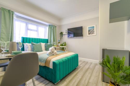 a bedroom with a bed and a table and a television at 12 Elmwood in Harrow