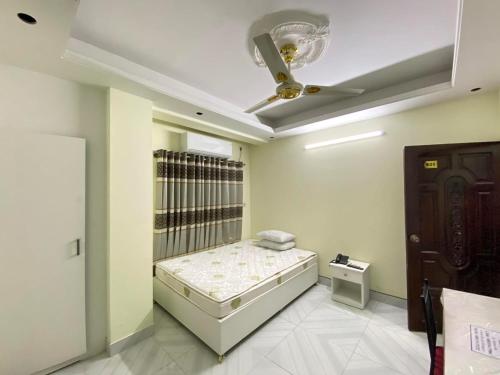 1 dormitorio con 1 cama y ventilador de techo en Hotel White Stone en Dhaka