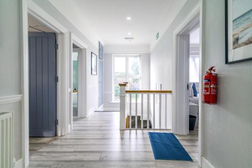 a hallway with a blue rug on the floor at 12 Elmwood in Harrow
