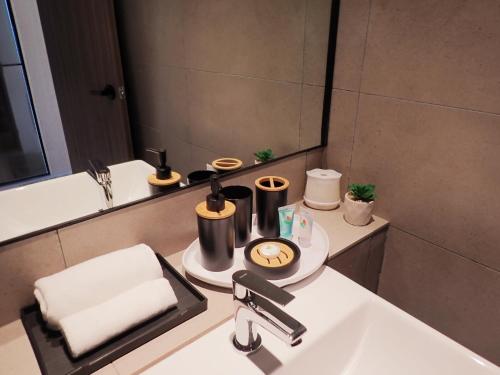 a bathroom with a sink and a mirror at RDHomeStay-RoxyBeachApt in Sematan
