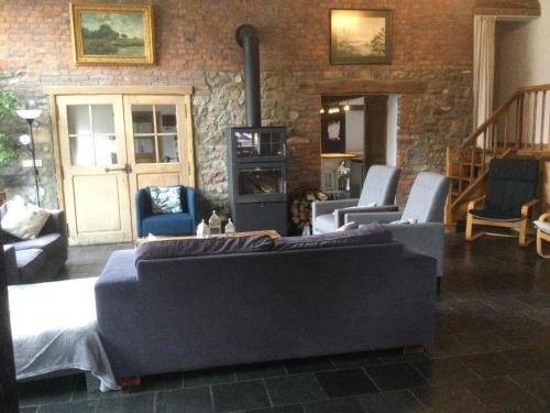a living room with couches and chairs and a brick wall at Maison Druyard huis met 5 slaapkamers in Durbuy