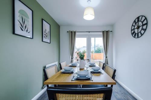 uma sala de jantar com uma mesa de madeira e cadeiras em Charming Home in Mossley with Free Parking and Wi-Fi Sleeps7 em Mossley