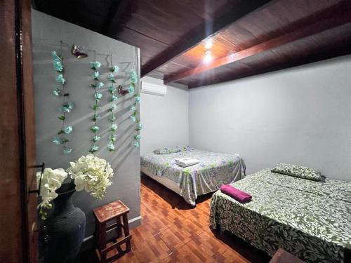 una habitación con 2 camas y un jarrón con flores en Hotel Pacific Surf Best Room In Tunco Beach Surf City, en El Sunzal