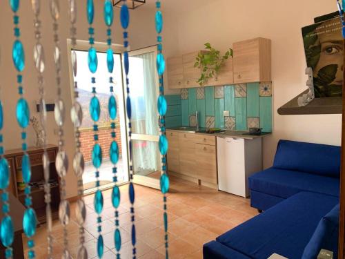 a living room with a blue couch and a kitchen at Butterflies Rest in Gubbio