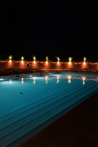 a swimming pool at night with lights in the background at Talbooth House & Spa in Dedham