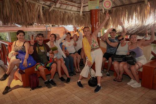 een groep mensen die in een bar zitten met hun handen in de lucht bij Ecohotel Yachay Tayrona in El Zaino