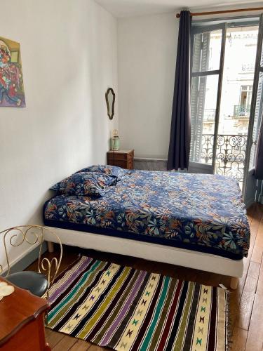 une chambre avec un lit et un tapis dans l'établissement Le Blaisois, à Blois