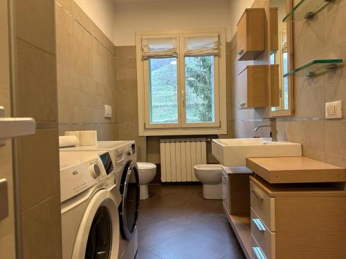 a bathroom with a washing machine and a sink at Welc-ōM luxury place in the hill in Galzignano