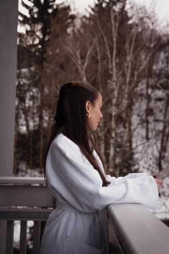 a young woman sitting on a railing in a dress at Anett hotel in Vipiteno