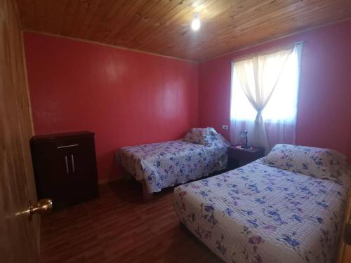 1 dormitorio con 2 camas y ventana en Cabaña El Quillay, en Linares