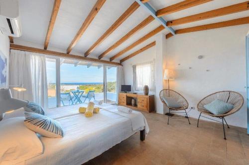 una camera con un grande letto e vista sull'oceano di Xaloc a Es Caló de Sant Agustí