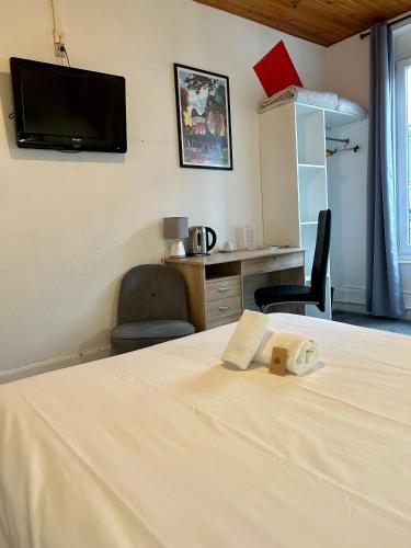 a bedroom with a bed with a tv on the wall at Hôtel & Restaurant Le Patio VICHY in Vichy