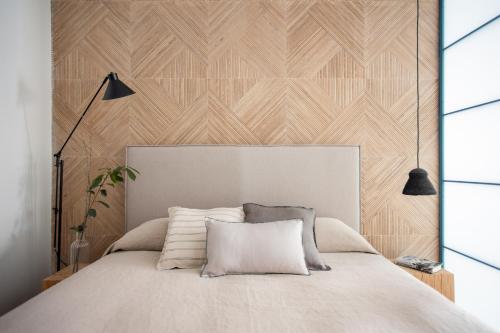 ein Schlafzimmer mit einem Bett mit einer Holzwand in der Unterkunft SEISSTA Madrid Centro "Remodelado" in Madrid