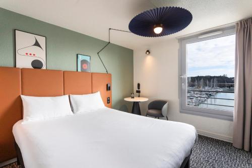 een hotelkamer met een bed en een raam bij ibis Granville Port De Plaisance in Granville