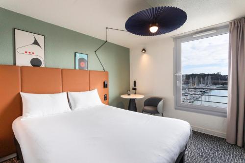 une chambre d'hôtel avec un lit et une fenêtre dans l'établissement ibis Granville Port De Plaisance, à Granville