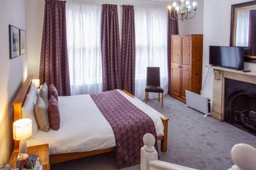 a hotel room with a bed and a fireplace at The Buttery in Oxford