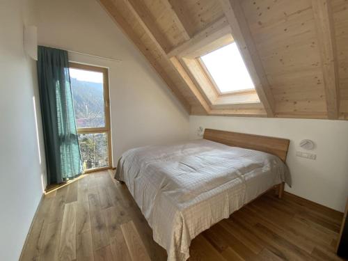 a bedroom with a bed and two windows at Ferienhaus Baiersbronn LUG INS TAL in Baiersbronn
