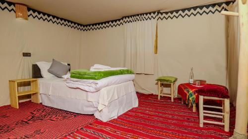 a bedroom with two beds and a red carpet at Nomad Camp in Erfoud
