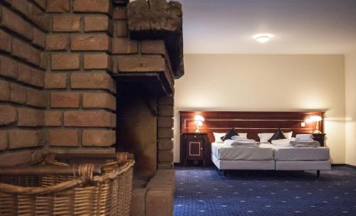 a bedroom with a bed and a brick wall at Stargaze Home Hotel in Haan