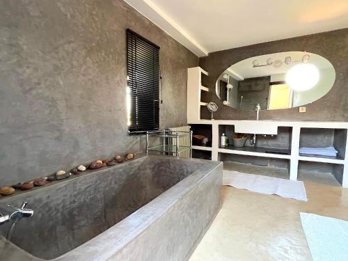 een badkamer met een groot bad en een spiegel bij Palais Ourikia in Marrakesh