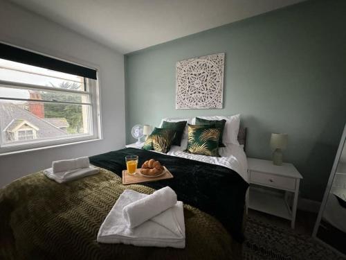 ein Schlafzimmer mit einem Bett und einem Tablett mit Essen drauf in der Unterkunft Sea View 2 Bed Apartment No 6 in Ryde