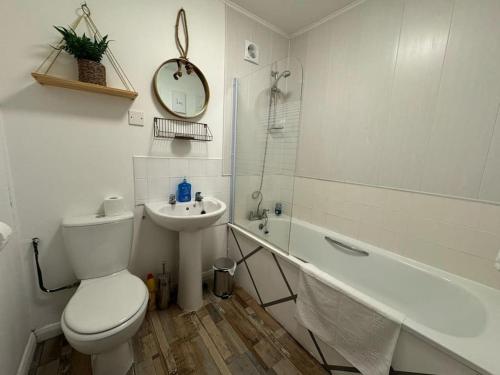 a bathroom with a toilet and a sink and a tub at Sea View 2 Bed Apartment No 6 in Ryde