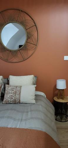 une chambre avec un lit avec un miroir au mur dans l'établissement Entre Uzès et le Pont du Gard La Cachette Romantique, à Collias