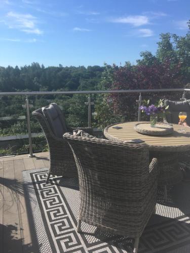 a patio with a table and chairs on a deck at Firbank House in Glenrothes