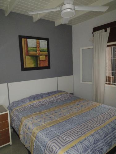 a bedroom with a bed and a painting on the wall at San Juan Apart in Santa Lucía