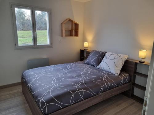 a bedroom with a bed and a window at Les maisons de la feuillade in Milhac-dʼAuberoche