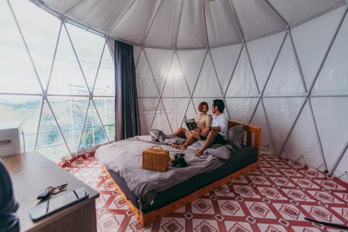 Due donne sedute su un letto in una tenda di MonLannaHomesty a Mon Jam