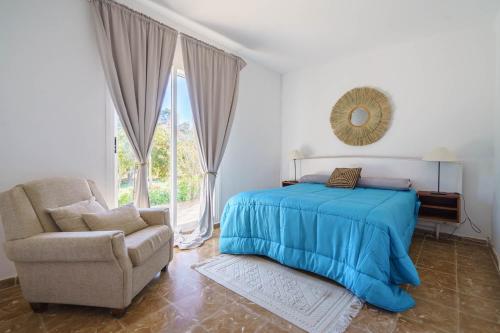 a bedroom with a bed and a chair and a mirror at Sa Palmera in Montuiri