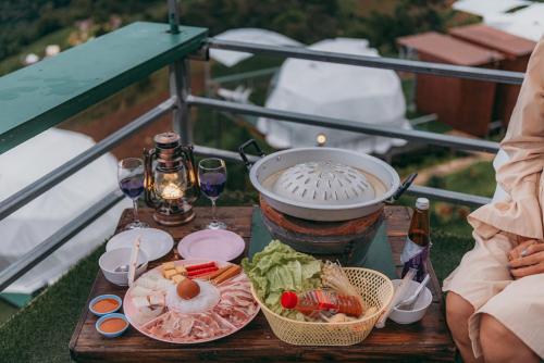einen Tisch mit Speisen und Wein auf dem Balkon in der Unterkunft MonLannaHomesty in Mon Jam