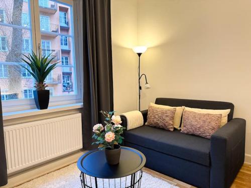 a living room with a blue couch and a table at Stay Inn Söder Cozy apartment in Stockholm