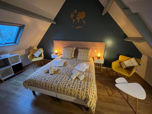 a bedroom with a large bed with two chairs at Domaine du Gros Chêne - terrasses avec jacuzzis privatifs in Ablon